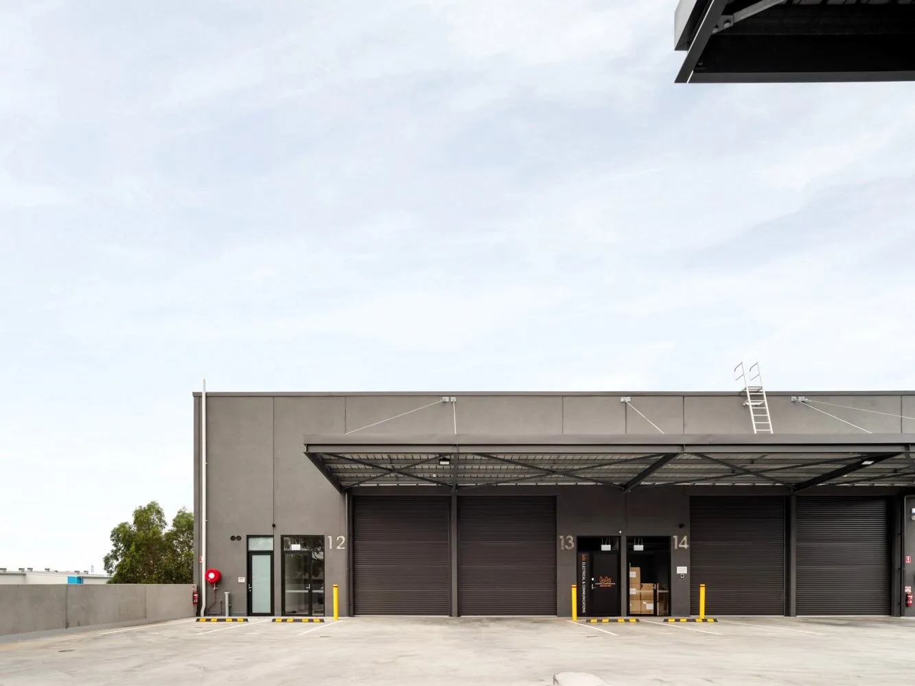 Warehouse exterior with loading docks and ladder.